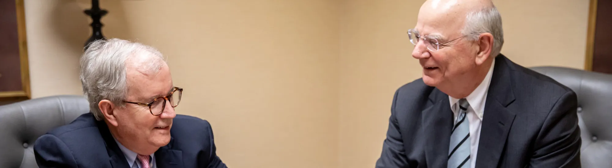 Mike and Rees discussing documents at a table.