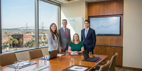 Professional meeting in a boardroom with four people and a graph on the screen.
